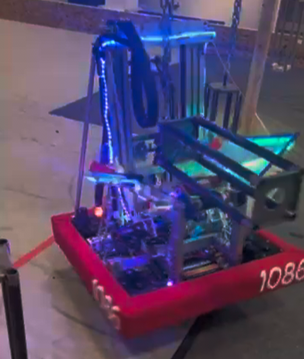 The robot using the climb arm to latch onto the steel structure hanging from a chain and pull itself up. 
      loading=